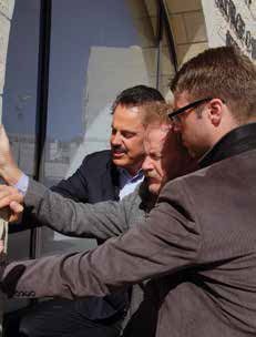 Dr. Evans, his son Michael, praying with Mike Atkins the day the contract to purchase the building was signed.